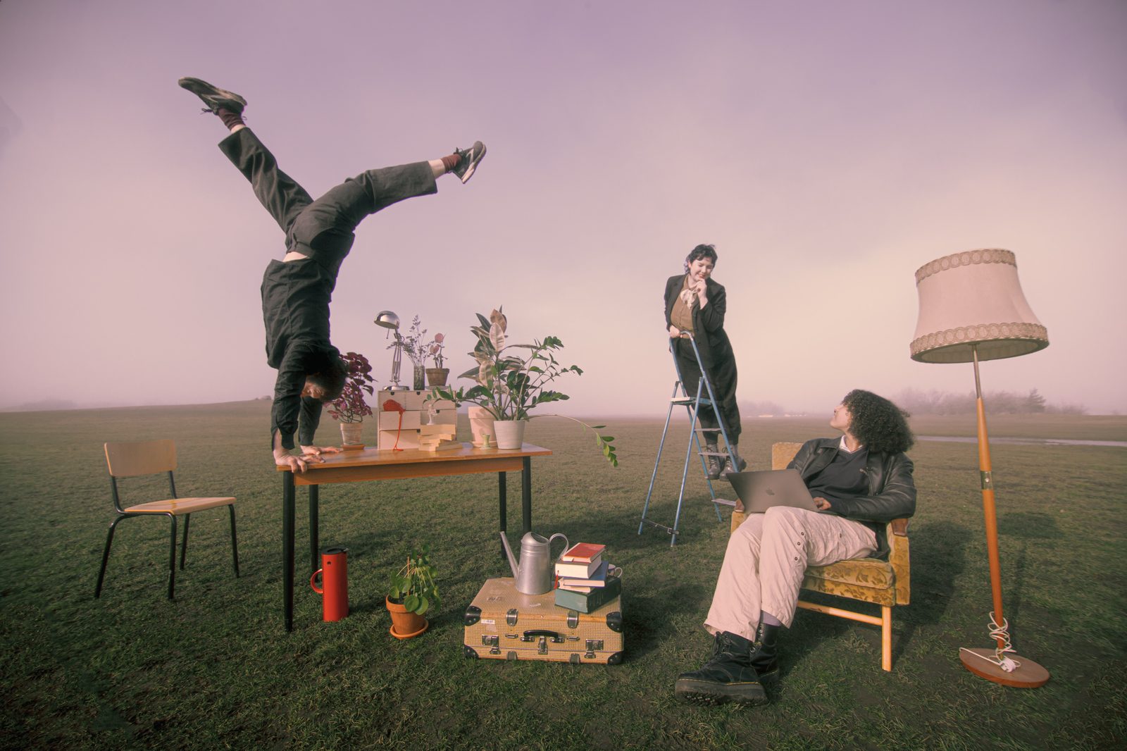 Handstående på bord i dimmig äng — surrealistisk cirkus