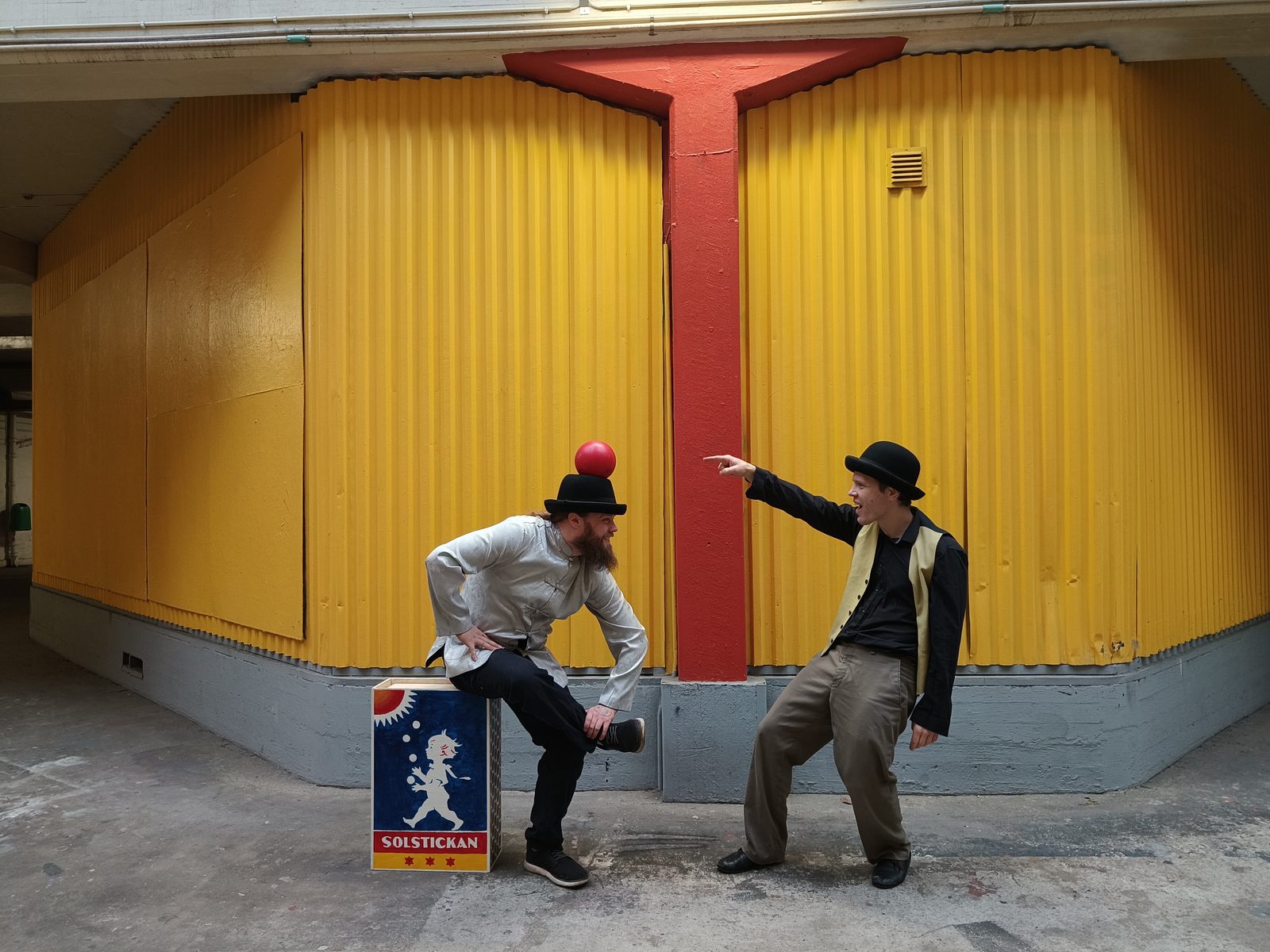 Cirkusduo framför gult plank